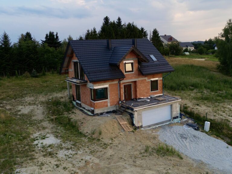 Raciborsko - elewacja frontowa domu z bramą garażową - dach, okna i drzwi wejściowe zamontowane
