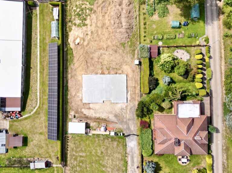 Budowa domu jednorodzinnego Radziszów - działka z płytą fundamentową z lotu ptaka, widok pionowy z drona